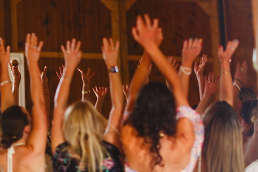 A circle of raised hands in the barn