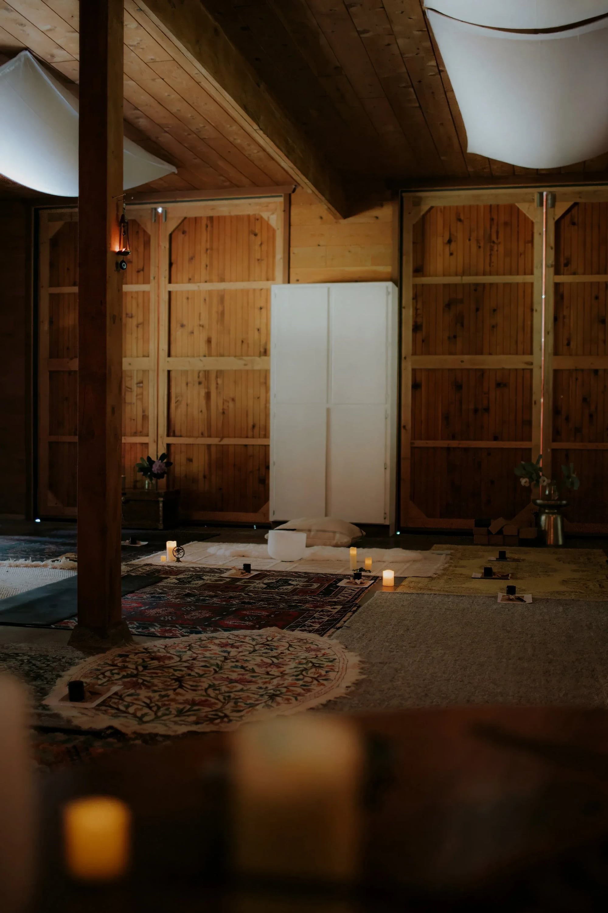 Candles and layered rugs set out inside the barn