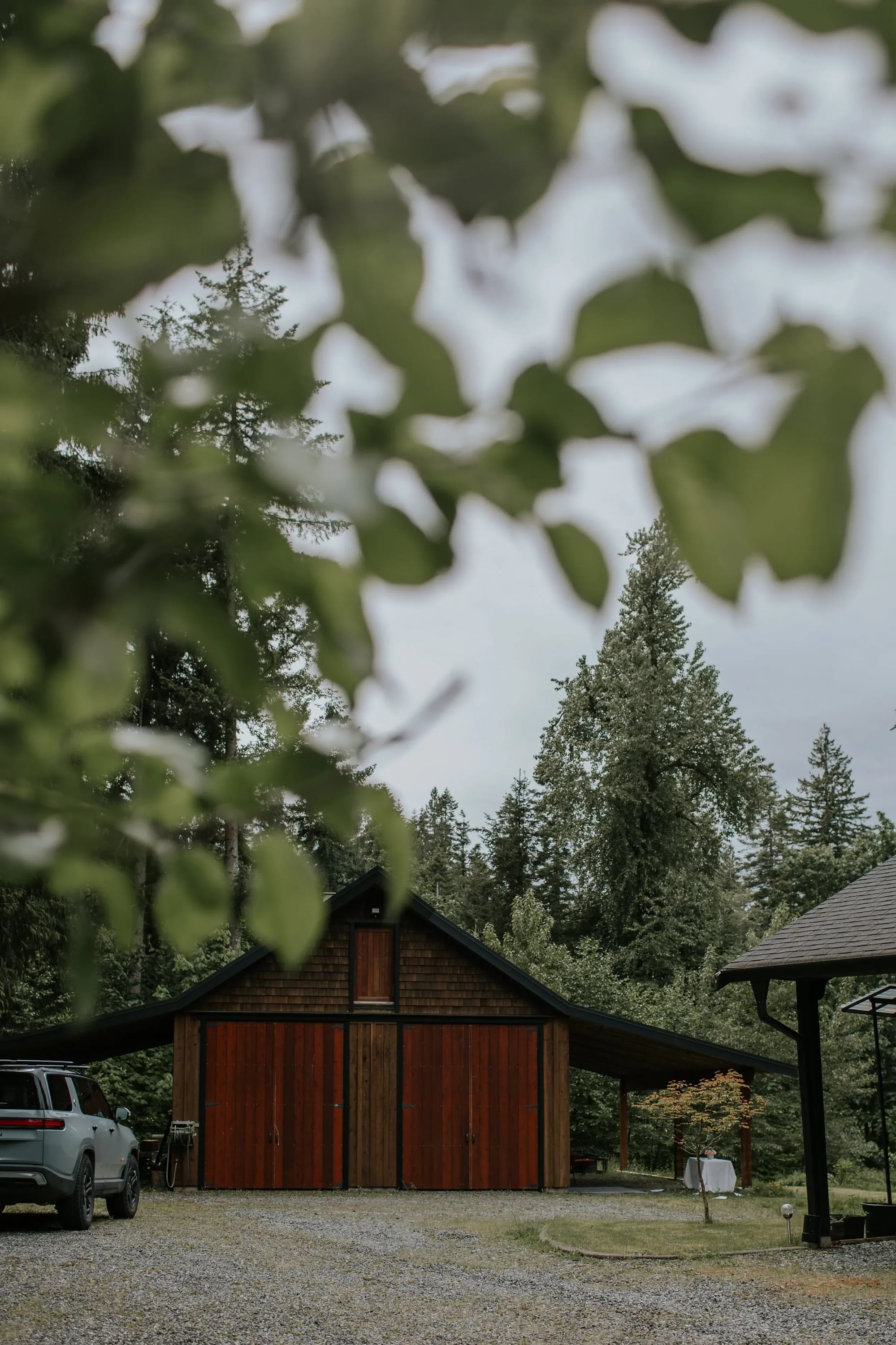 The barn, with red cedar doors, among tall firs